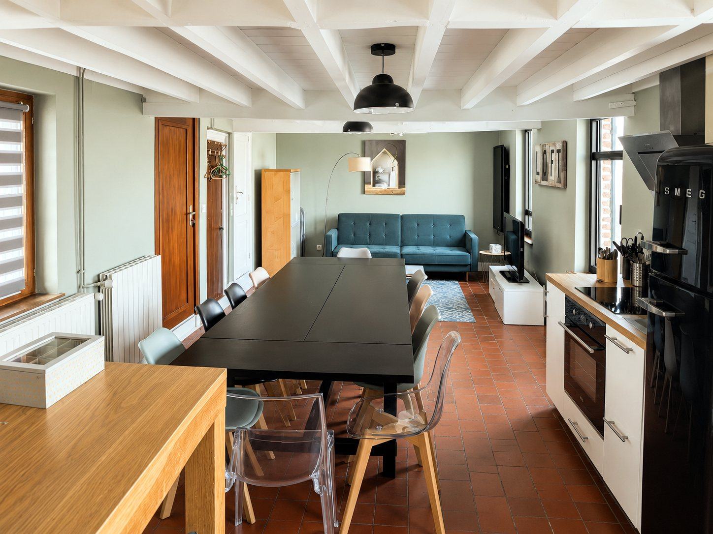 Séjour lumineux avec grande table et cuisine ouverte